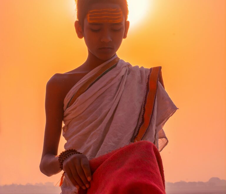 A Brahmin boy with a towel on his head prepares pooja materials for the evening arti ceremony.